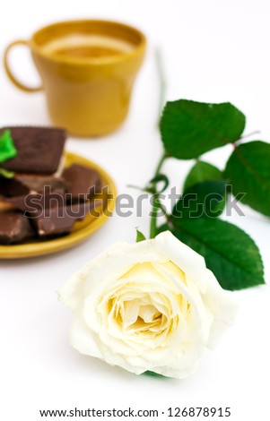White rose with cup of coffee, over white, shallow depth of field