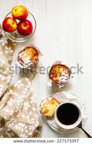 Fresh breakfast table with muffins in paper cupcake holders, coffee and fruits (peach and nectarine). Concept of good morning and tasty food.