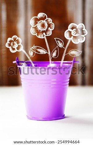Spring and easter concept with purple bucket and sketched white flowers