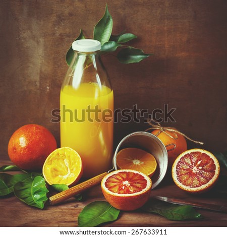 Still life with orange fruit and juice on wooden table. Painting style. Selective focus. Instagram color effect.