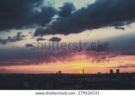 Epic Dramatic Sunset Sky in Industrial City. Silhouette of City. Selective Focus. Image toned with Retro Color Effect.