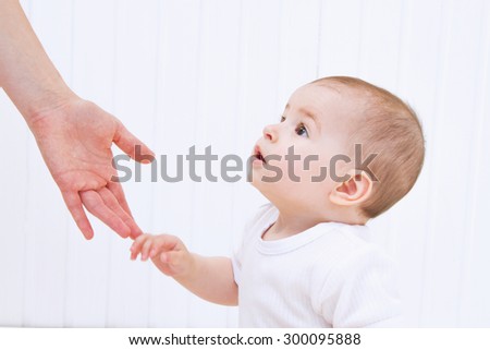 Beautiful baby with mother hand help on white background