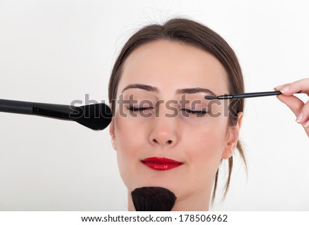 Applying lipstick by looking at mirror