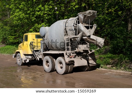 concrete mixer with yellow cab over trees