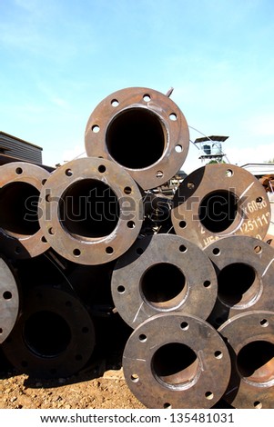 Stack of rust steel pipes in outdoor warehouse