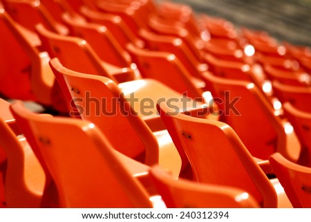 Rows of plastic chairs in a football stadium.