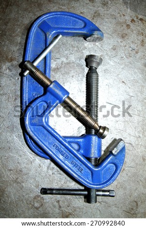 Blue steel clamp on steel background
