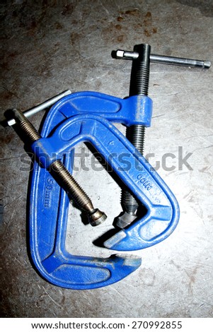 Blue steel clamp on steel background