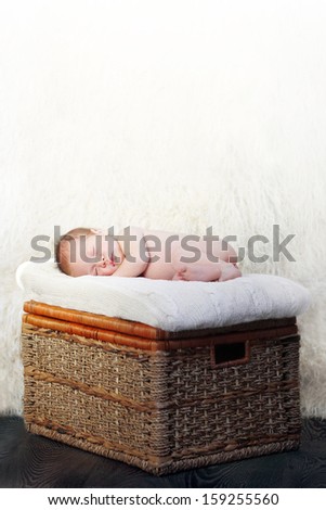baby sleeping on a wicker box