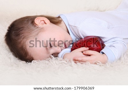 the little boy fell asleep in the arms of an apple