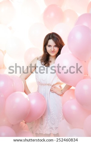 beautiful girl in a large number of pink and white balloons