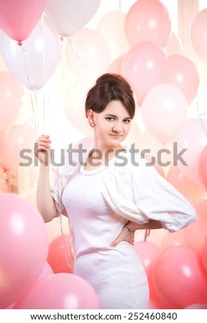 beautiful girl in a large number of pink and white balloons