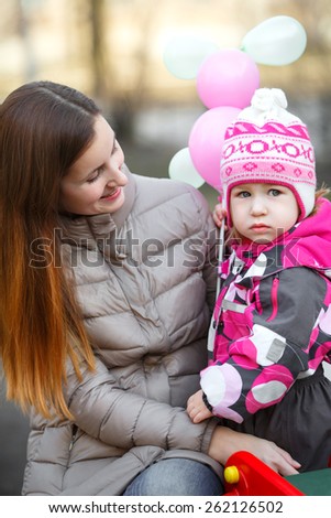 Mom and daughter  on a park bench in spring day