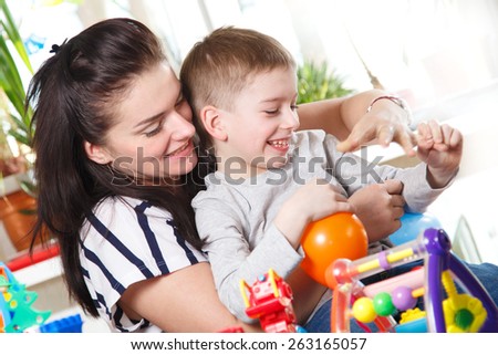 woman and boy fooling around with balloons in home interior