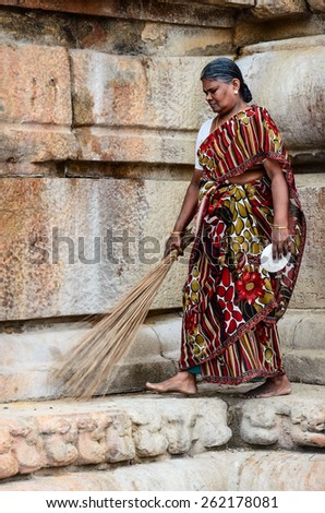THANJAVUR, INDIA - FEBRUARY 14: An unidentified Indian woman in national dress carries sweeping a broom at Brihadishwara Temple. India, Tamil Nadu, Thanjavur. February 14, 2013.