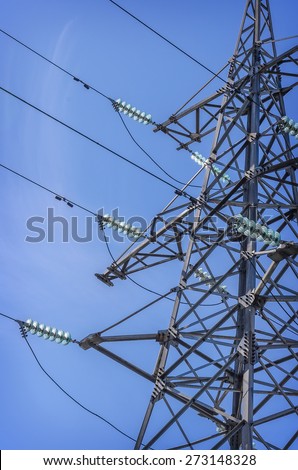 High-voltage tower isolated on blue sky background.