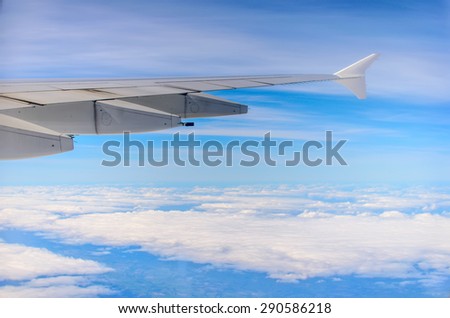 View from the airplane window, aircraft wing on the clouds