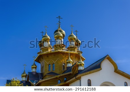 The golden dome on the  wooden russian church of the Holy Martyrs Faith, Hope and Charity and their mother Sophia in Belgorod, Russia. Close-up photo.