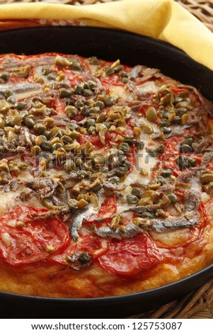 A recipe of pizza with tomato anchovy and capers