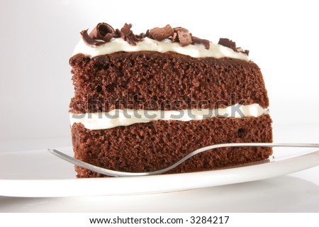 Slice of chocolate cake stuffed with whipped cream, covered with whipped cream and white chocolate on neutral background