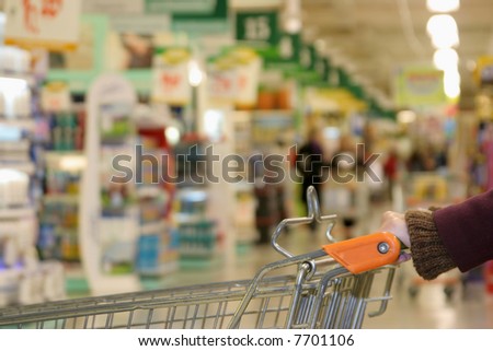 Shopping cart on supermarket, blurred background