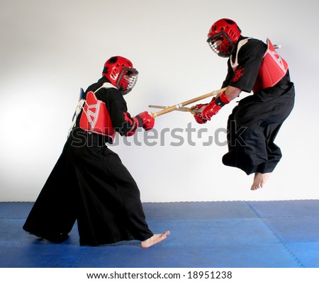 Two martial arts practicing fighting with wood swords
