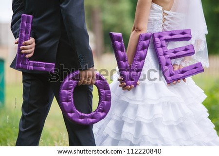 Bride and groom holding the letter\
the word love\
word love composed of letters handmade\
Sew Fabric word love