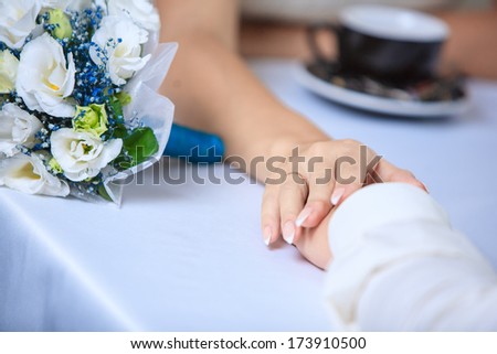 Man and woman\'s hands and coffee cups with hearts man\'s and woman\'s hands on the table in cafe lovers holding hands in cafe
