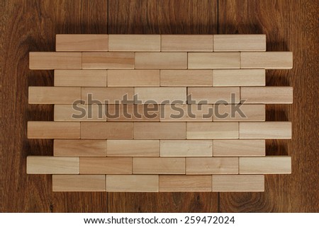 solid wall of wooden bars densely stacked wooden blocks on the floor with parquet blocks wood game (jenga)