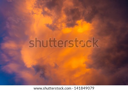 Ominous sky plays with light. sky becomes dark purple clouds. yellow-orange light from the sun breaks through the storm.