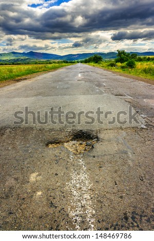 broken highway with hole in the direction of mountains