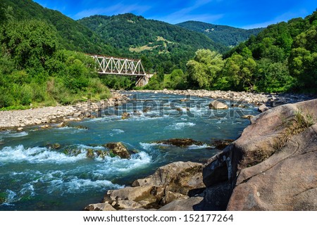 Iron Bridge and a giant stone on the opposite side of the river in the mountains