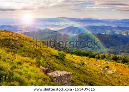 mountain landscape. valley with stones on the hillside. forest on the mountain under the beam of light falls on a clearing at the top of the hill.