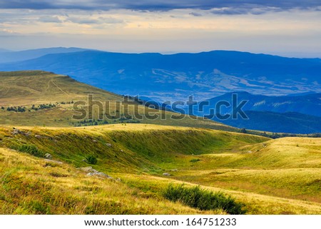mountain landscape. valley with stones on the hillside. forest on the mountain and clearing at the top of the hill.