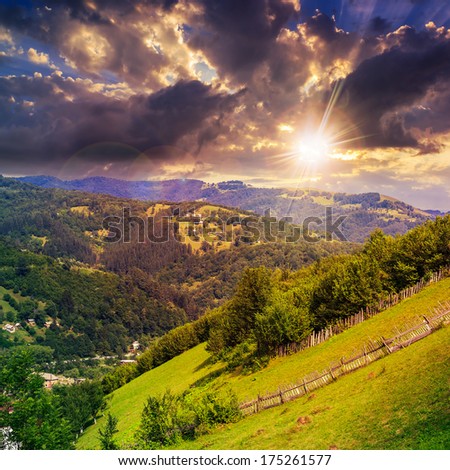 autumn landscape. village on the hillside. forest on the mountain light fall on clearing on mountains in evening