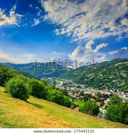 summer landscape. village on the hillside. forest on the mountain light fall on clearing on mountains