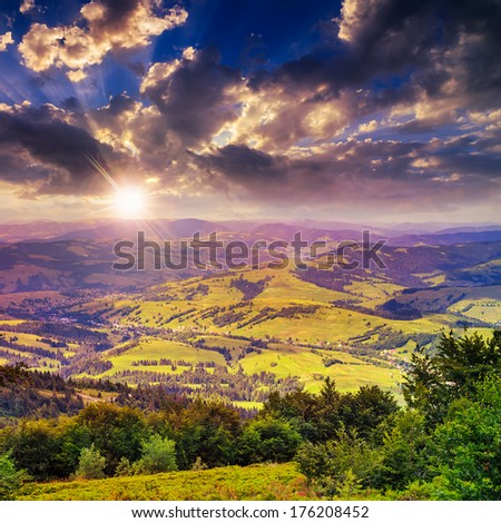 autumn landscape. village on the hillside. forest on the mountain light fall on clearing on mountains at sunset