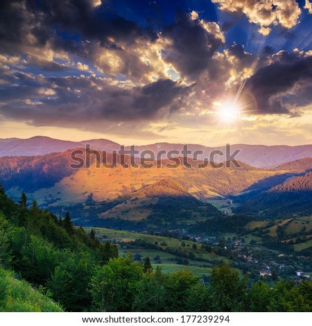 autumn landscape. village on the hillside. forest on the mountain light fall on clearing on mountains at sunset light