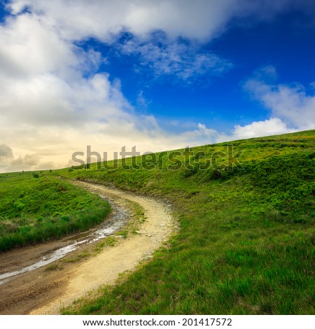 summer landscape. mountain path through the field turns uphill to the sky