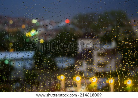 abstract background raindrops on glass on background of blurred warm  with cool blue and purple lights with bokeh effect