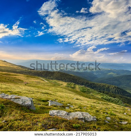 mountain landscape. valley with stones on the hillside. forest on the mountain under the beam of light falls on a clearing at the top of the hill at sunrise