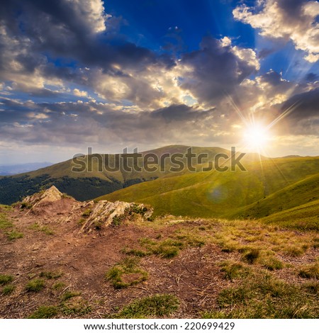 mountain landscape. valley with stones on the hillside. forest on the mountain under the beam of light falls on a clearing at the top of the hill  at sunset