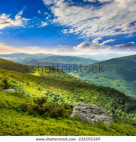 mountain landscape. valley with stones on the hillside. forest on the mountain under the beam of light at the top of the hill.