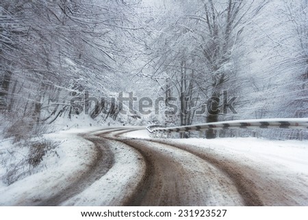 abstract speed blur of asphalt curve road in winter forest