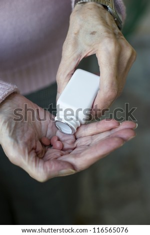 Senior woman hands Close up of senior woman\'s hands taking her medicines