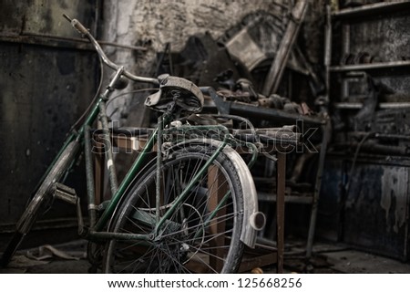 Bicycle in a dirty warehouse. An old bicycle in a dirty and dark warehouse.