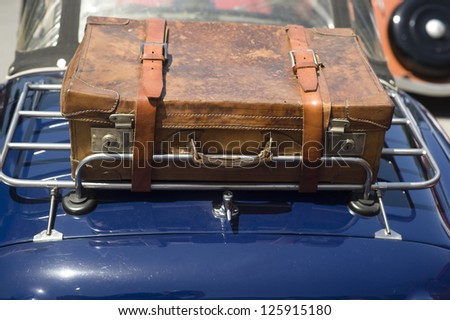 Luggage rack and suitcase. A rear luggage rack with an old suitcase on a classic car