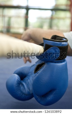 Boxing gloves. Boxing gloves hanging from a rope in a fighting ring