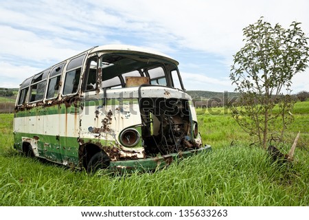 Abandoned old bus in a green field