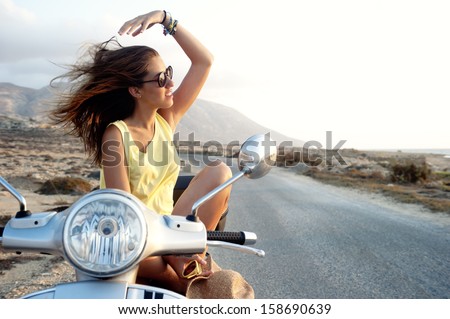 Young female on motorcycle trip. Young female enjoys a motorcycle trip and admires the view